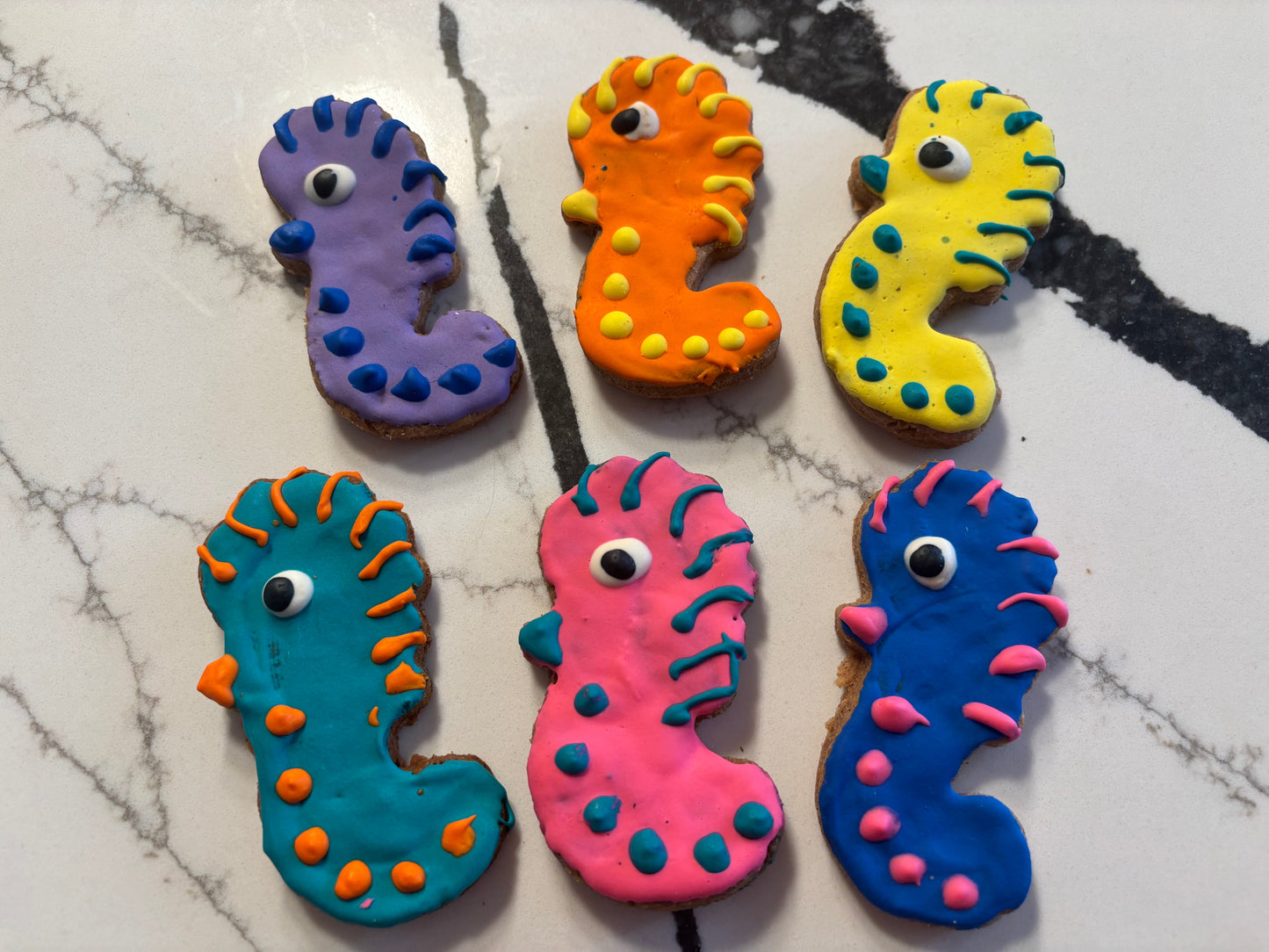 Colorful fish-shaped PAWaquarium dog treats made with organic peanut butter and cinnamon.