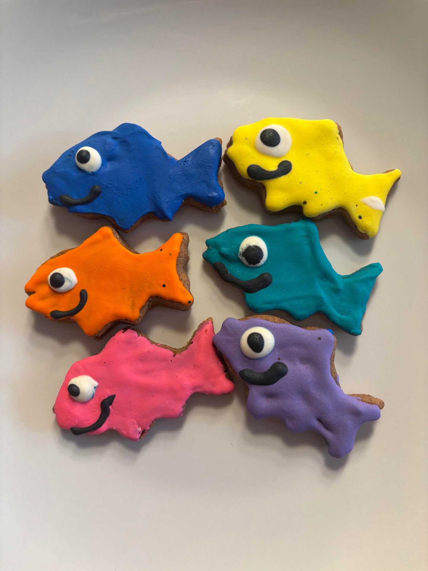 Colorful fish-shaped PAWaquarium dog treats made with organic peanut butter and cinnamon.