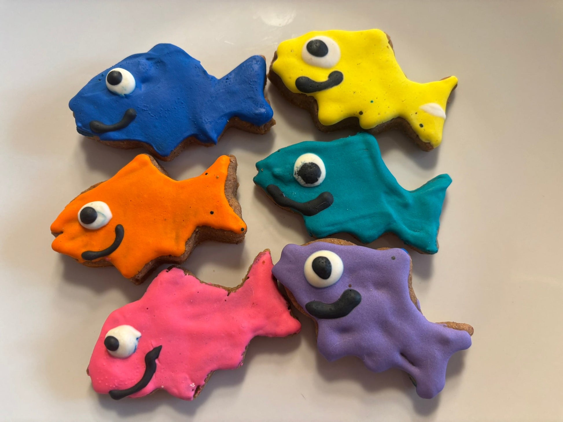 Colorful fish-shaped PAWaquarium dog treats made with organic peanut butter and cinnamon.