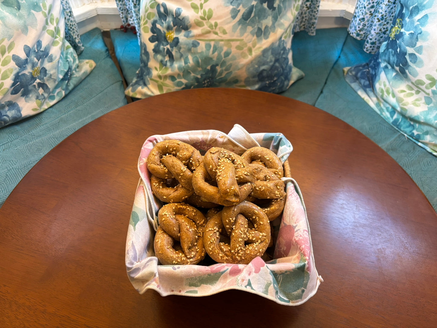 Basket of organic dog pretzel treats displayed on a wooden table with cozy home background