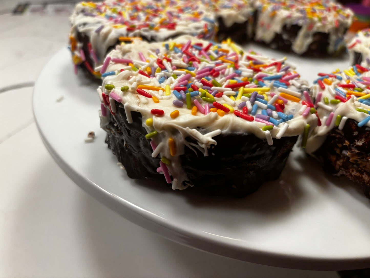 Close up of Pawfetti Cake dog treat with peanut butter frosting and rainbow sprinkles