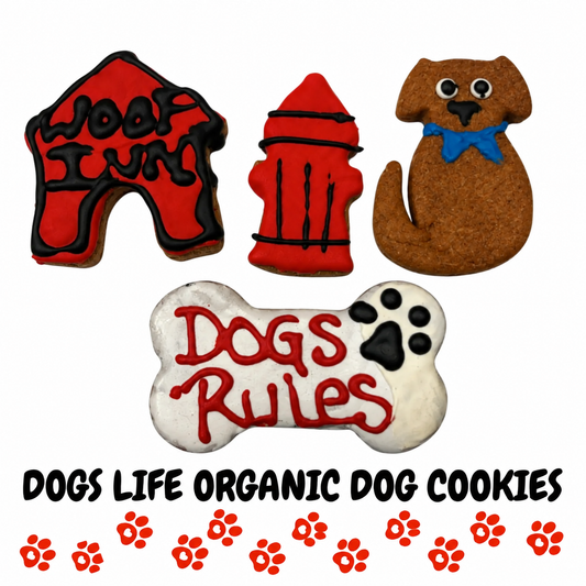 Four Dogs Life organic dog cookies by PAWsitively Organic Dog Bakery, featuring a red doghouse, fire hydrant, brown dog with blue bow, and white Dogs Rule bone cookie. Handmade, decorated dog treats displayed on a clean white background.