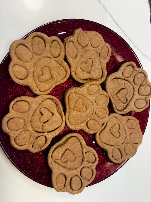 Organic paw print dog cookies with heart detail on red plate, handmade all-natural dog treats