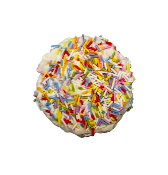 Close up of Pawfetti Cake dog treat with peanut butter frosting and rainbow sprinkles