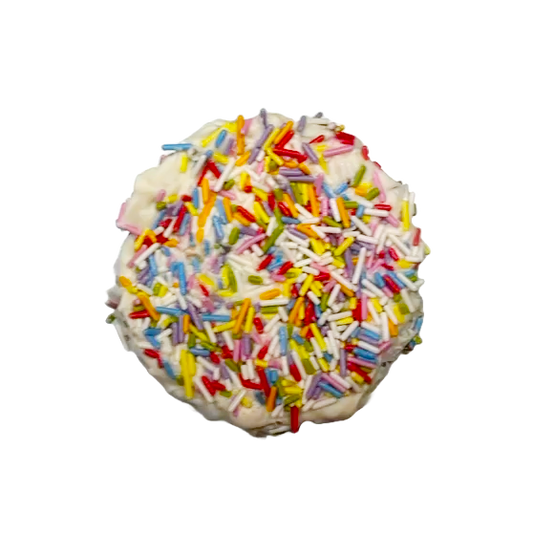Close up of Pawfetti Cake dog treat with peanut butter frosting and rainbow sprinkles